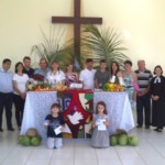 Membros da Comunidade em Campos de Júlio (12 famílias no total) com cartaz e cofrinhos da Campanha em frente ao altar!